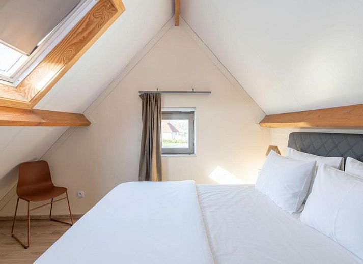 Moderne keuken en eetruimte in vakantiehuis Westhinder I H12, Koksijde, met houten balken en veel lichtinval.