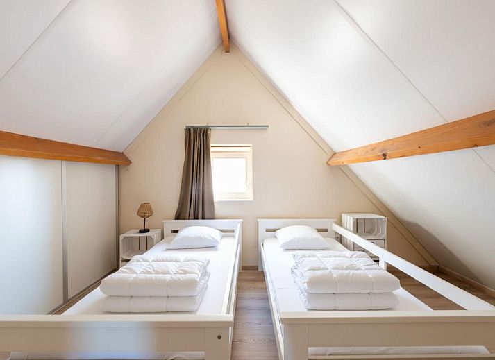 Moderne keuken en eetruimte in vakantiehuis Westhinder I H12, Koksijde, met houten balken en veel lichtinval.
