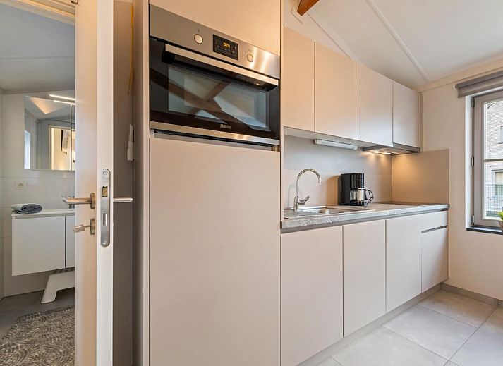Moderne woonkamer van vakantiehuis Westhinder II H18 in Koksijde, West-Vlaanderen, met ruime zithoek en veel natuurlijk licht.