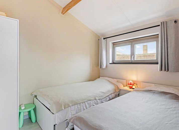 Gezellige woonkamer in vakantiehuis Westhinder II H18, Koksijde, met comfortabele bank en moderne inrichting, ideaal voor ontspanning in West-Vlaanderen.