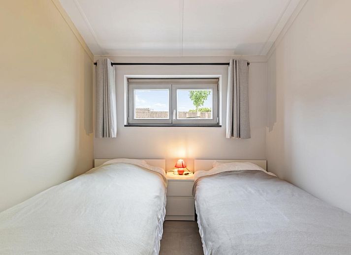 Gezellige woonkamer in vakantiehuis Westhinder II H18, Koksijde, met comfortabele bank en moderne inrichting, ideaal voor ontspanning in West-Vlaanderen.