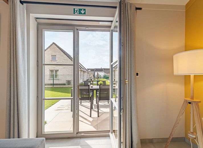 Gezellige woonkamer in vakantiehuis Westhinder II H18, Koksijde, met comfortabele bank en moderne inrichting, ideaal voor ontspanning in West-Vlaanderen.
