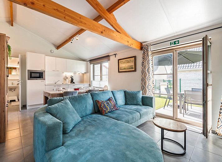 Gemuetliches Wohnzimmer des Ferienhauses Westhinder II H19 in Koksijde, Westflandern, mit bequemem Sofa und rustikalen Moebeln.