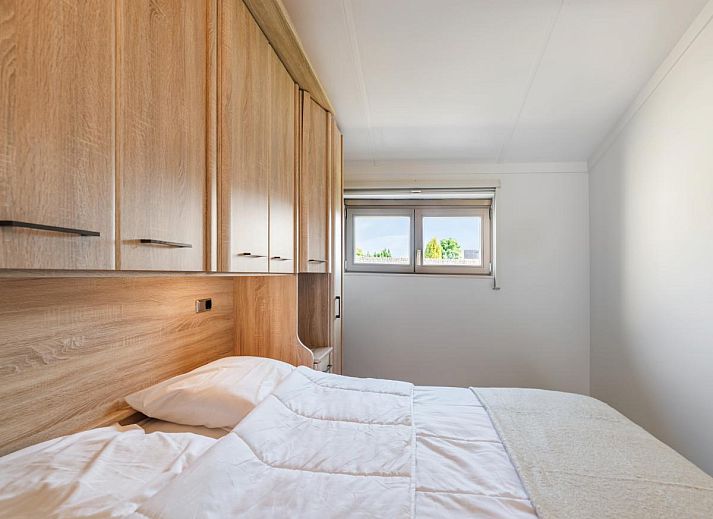 Gemuetliches Wohnzimmer des Ferienhauses Westhinder II H19 in Koksijde, Westflandern, mit bequemem Sofa und moderner Kueche.