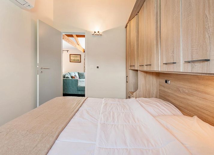 Gemuetliches Wohnzimmer des Ferienhauses Westhinder II H19 in Koksijde, Westflandern, mit bequemem Sofa und moderner Kueche.