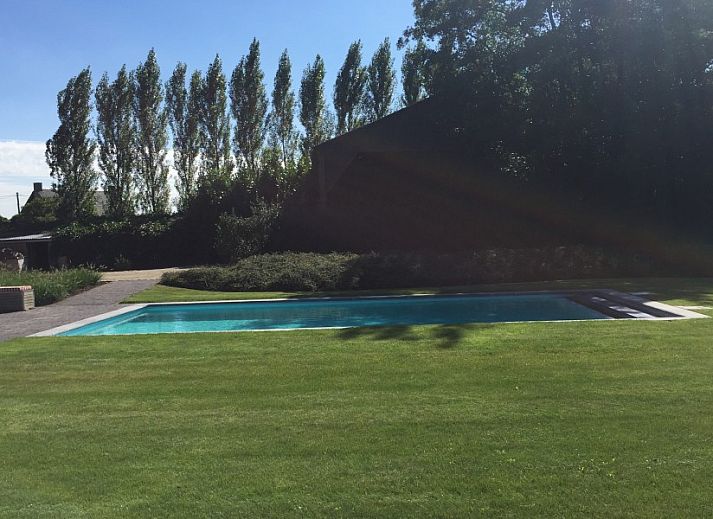 Eetkamer in Vakantiehuis Sylvain, Tielt, West-Vlaanderen, met uitzicht op de tuin en veel natuurlijk licht.