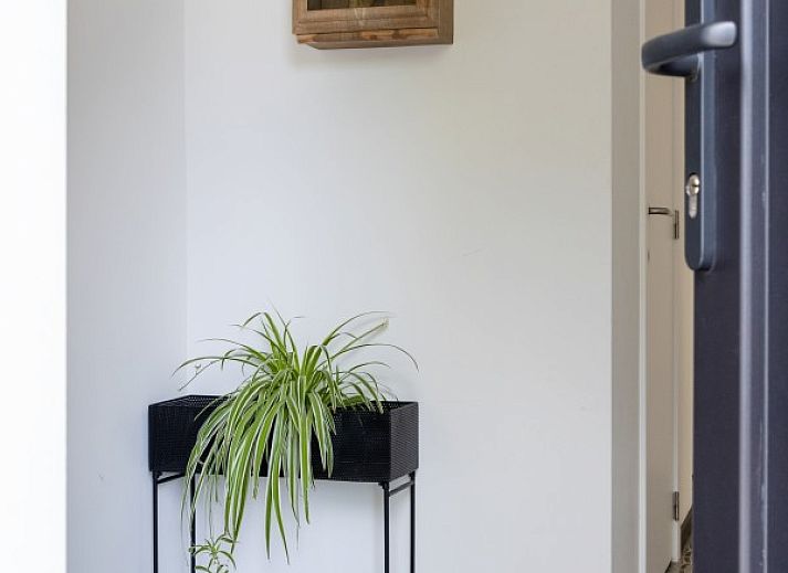 Heller Eingang zum Ferienhaus 't hov in Passendale mit stilvollem Fliesenboden und modernen Moebeln.