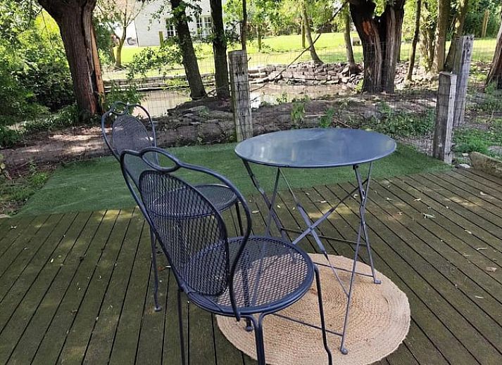 Cozy porch of Holiday Home in Zarren overlooking green fields in West Flanders, Belgium.
