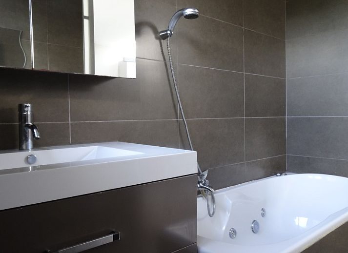 Gemuetliches Wohnzimmer des Ferienhauses Maison Miest in Watou, Westflandern, mit bequemen Sofas und Kamin.