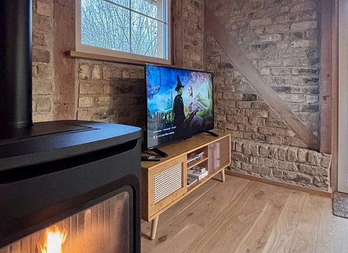 Cozy living room of Cottage in Alveringem, vacation home in West Flanders, with wood stove and television for ultimate relaxation.