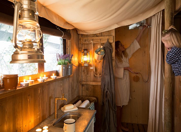 Gemuetliche Terrasse des Zelthauses mit privater Warmwasserdusche in der ruhigen Landschaft von Poperinge, Westflandern, Belgien.