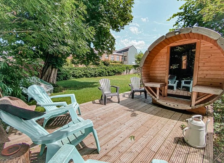 Aussenterrasse des Gaestehauses Skindles in Poperinge, Westflandern, mit Sonnenschirmen und Sitzgelegenheiten.