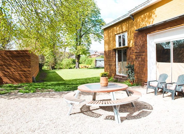 Aussenterrasse des Gaestehauses Skindles in Poperinge, Westflandern, mit Sonnenschirmen und Sitzgelegenheiten.