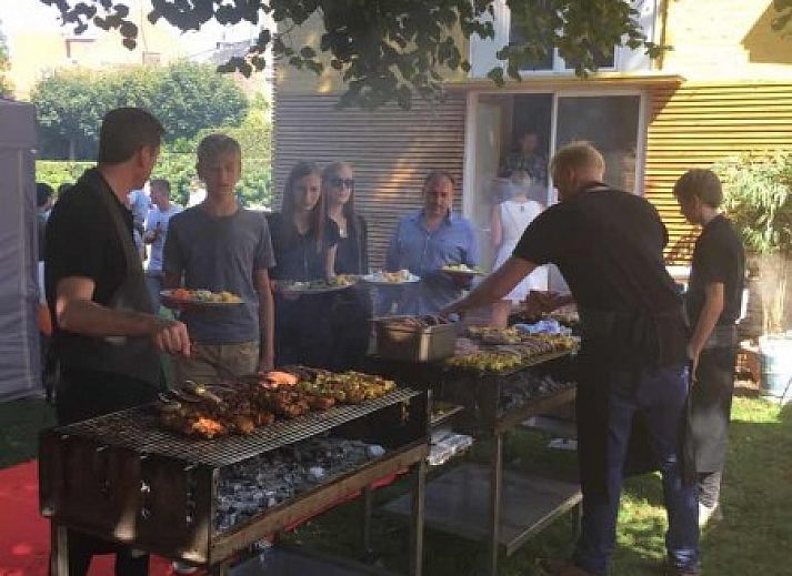 Aussenterrasse des Gaestehauses Skindles in Poperinge, Westflandern, mit Sonnenschirmen und Sitzgelegenheiten.