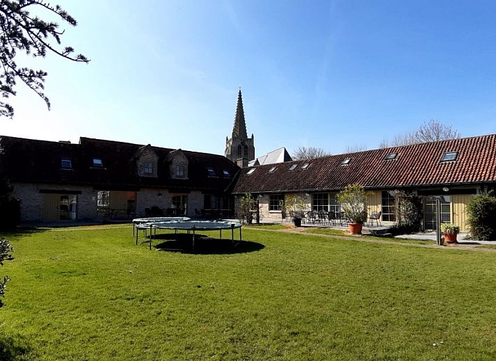 Speelruimte bij 't Kapelhof vakantiehuis in Beauvoorde, West-Vlaanderen met schommels en trampoline.