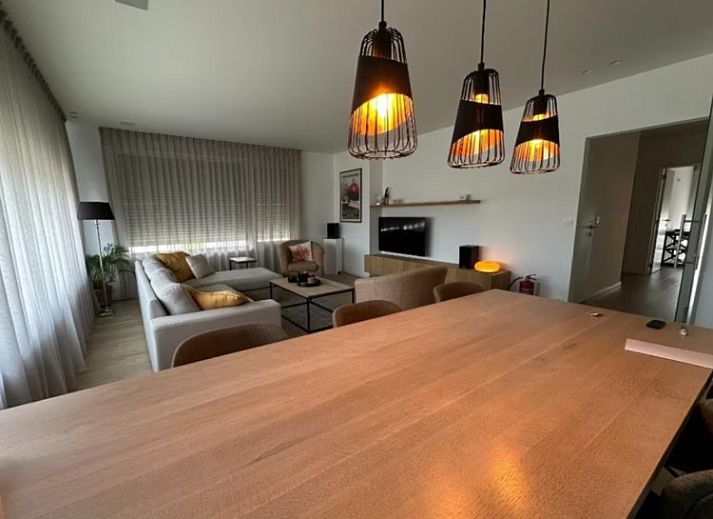 Blick auf den historischen Turm von Flat Memling in Sint-Andries, Westflandern, Belgien, umgeben von baumbestandenen Daechern.