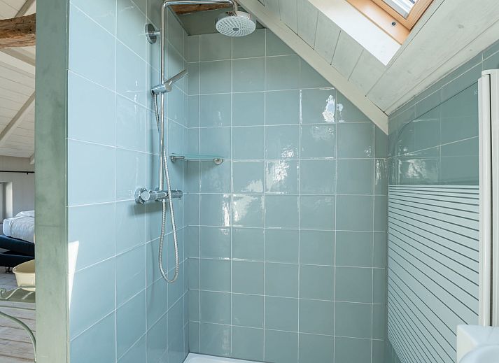 Sfeervolle slaapkamer in Vakantiehuis Gigi, een rustiek vakantiehuis in Vlissegem, West-Vlaanderen, met houten interieur en dakraam.