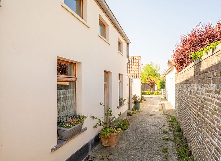 Sfeervolle slaapkamer in Vakantiehuis Gigi, een rustiek vakantiehuis in Vlissegem, West-Vlaanderen, met houten interieur en dakraam.