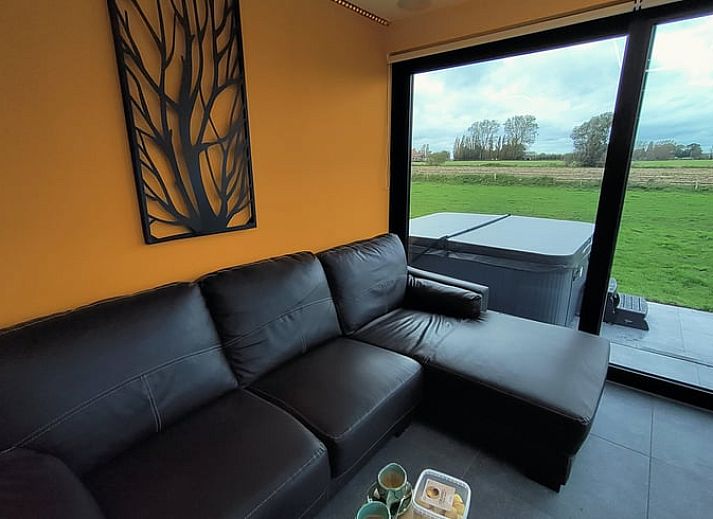 Gemuetliche Terrasse des Cottage in Ingooigem, Ferienunterkunft in Westflandern, mit Sitzgelegenheiten und gruener Umgebung.