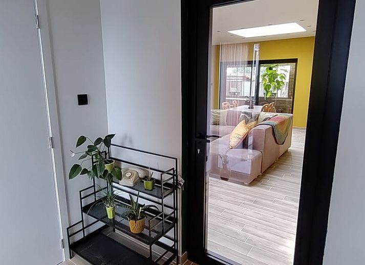 Gemuetliche Terrasse des Cottage in Ingooigem, Ferienunterkunft in Westflandern, mit Sitzgelegenheiten und gruener Umgebung.