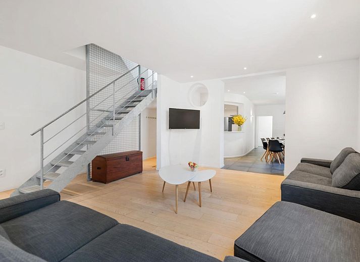 Stilvolles Wohnzimmer des Ferienhauses "De Loft" in Veurne, Westflandern, mit moderner Einrichtung und einer grosszuegigen Sitzecke.