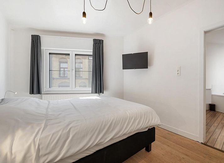 Schlafzimmer im Ferienhaus "De Loft" in Veurne, Westflandern, mit moderner Einrichtung und Zugang zu einer sonnigen Terrasse.