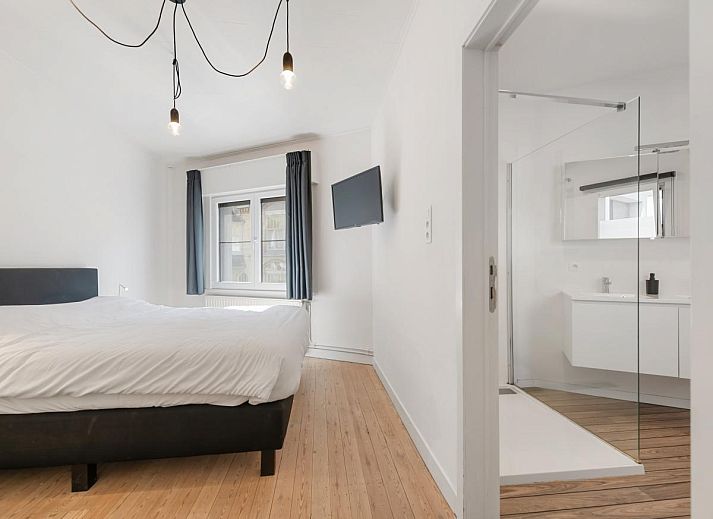 Schlafzimmer im Ferienhaus "De Loft" in Veurne, Westflandern, mit moderner Einrichtung und Zugang zu einer sonnigen Terrasse.
