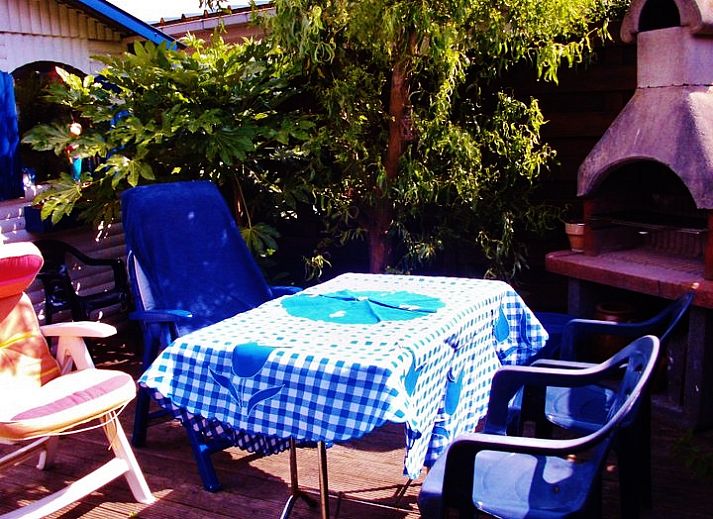 Ruime tuin van vakantiewoning Katica in Bredene, West-Vlaanderen met ligstoelen en barbecue