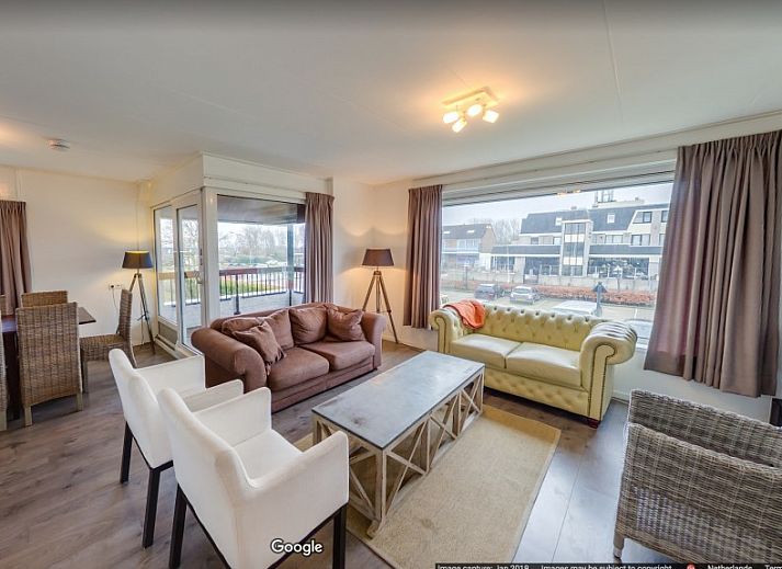 Gezellige woonkamer van La Cabane Penthouse in Aan zee, Belgische kust, vakantiehuis met open haard en ruime zithoek.