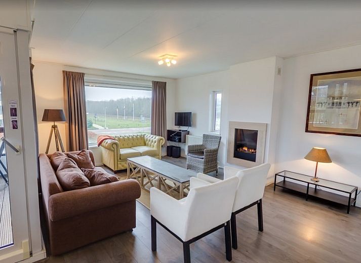 Gezellige woonkamer van La Cabane Penthouse in Aan zee, Belgische kust, vakantiehuis met open haard en ruime zithoek.