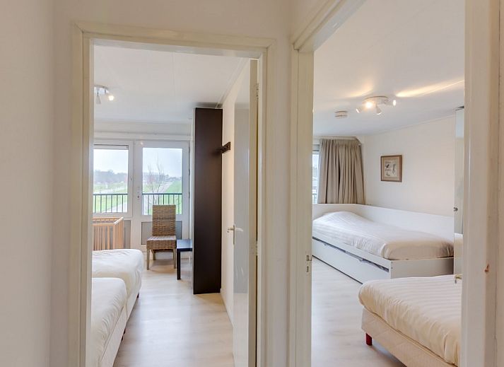 Lichte woonkamer van La Cabane Penthouse, vakantiehuis aan de Belgische kust met comfortabele zitruimte en uitzicht op de omgeving.