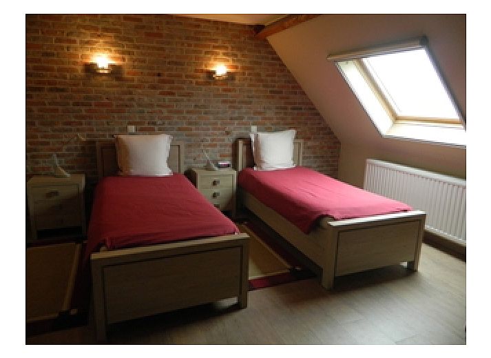 Historische binnenplaats van Varlet Farm bed and breakfast in Poelkapelle, Belgie, omgeven door bakstenen gebouwen.