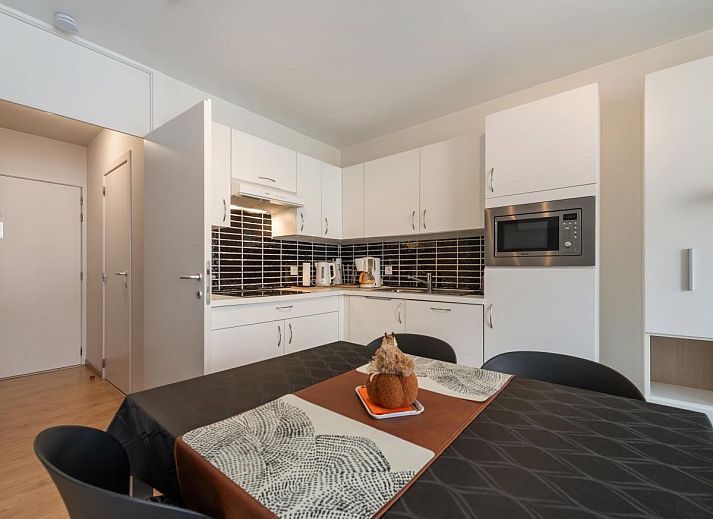 Modernes Wohnzimmer im Ferienhaus Tranquil a Deux, De Panne, mit heller Einrichtung und Blick auf die Umgebung von Westflandern, Belgien.