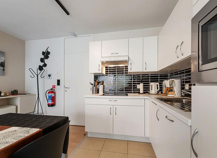 Modernes Wohnzimmer im Ferienhaus Tranquil a Deux, De Panne, mit heller Einrichtung und Blick auf die Umgebung von Westflandern, Belgien.