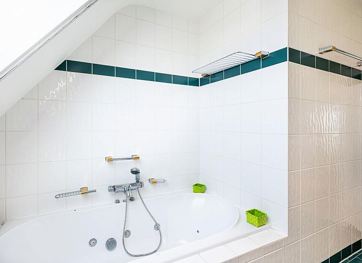 Moderne Kueche im Ferienhaus LaRoyale, De Panne, Westflandern, mit stilvollem Essbereich und schlichten weissen Schraenken.