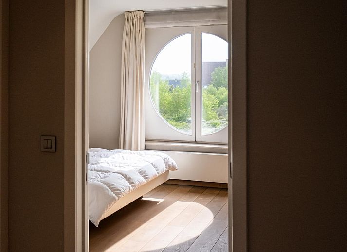 Moderne Kueche im Ferienhaus LaRoyale, De Panne, Westflandern, mit stilvollem Essbereich und schlichten weissen Schraenken.