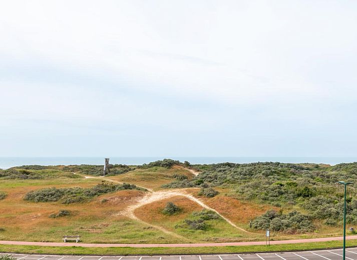 Moderne Kueche im Ferienhaus LaRoyale, De Panne, Westflandern, mit stilvollem Essbereich und schlichten weissen Schraenken.