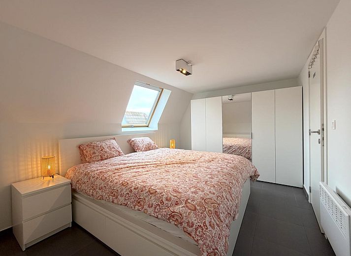 Gemuetliches Wohnzimmer im Ferienhaus Home Sweet Home, De Panne, mit moderner Einrichtung und Blick auf den gruenen Garten in Westflandern, Belgien.