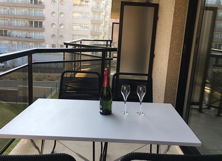 Stylish brown sofa in Residence Noordhinder apartment, De Panne, Belgian coast, with colorful cushions and art on the wall.