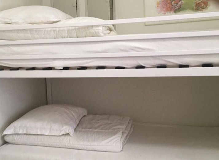 Stylish brown sofa in Residence Noordhinder apartment, De Panne, Belgian coast, with colorful cushions and art on the wall.