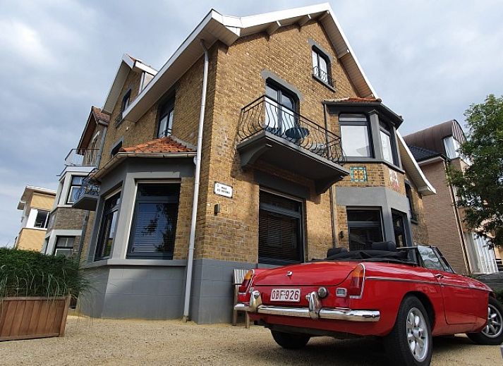 Die Villa Les Rosiers in De Panne, Belgien, bietet ein charmantes Aeusseres mit klassischer Architektur und einer einladenden Terrasse.