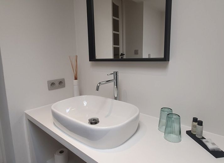 Gemuetlicher Aufenthaltsraum in der Villa Les Rosiers, De Panne, Belgien, mit einer Dartscheibe und einem Tischfussball.