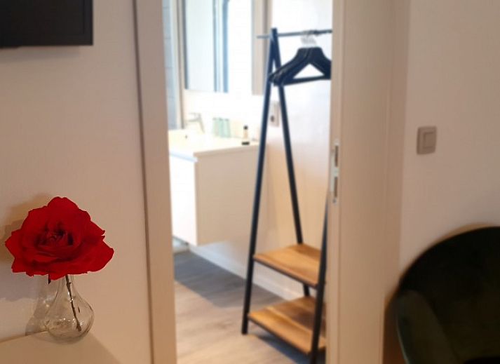 Gemuetlicher Aufenthaltsraum in der Villa Les Rosiers, De Panne, Belgien, mit einer Dartscheibe und einem Tischfussball.