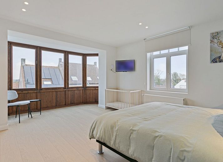 Diele von Maison Perron, Ferienhaus De Panne, Westflandern mit Holztreppe und altem Stuhl.