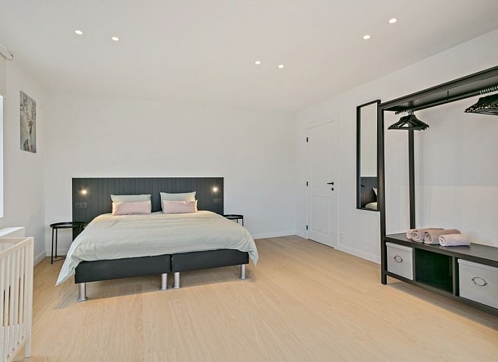 Diele von Maison Perron, Ferienhaus De Panne, Westflandern mit Holztreppe und altem Stuhl.