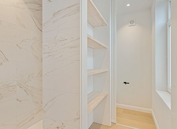 Gemuetliches Wohnzimmer von Maison Perron, Ferienhaus De Panne, Westflandern mit bequemem Sofa und Kunst an der Wand.