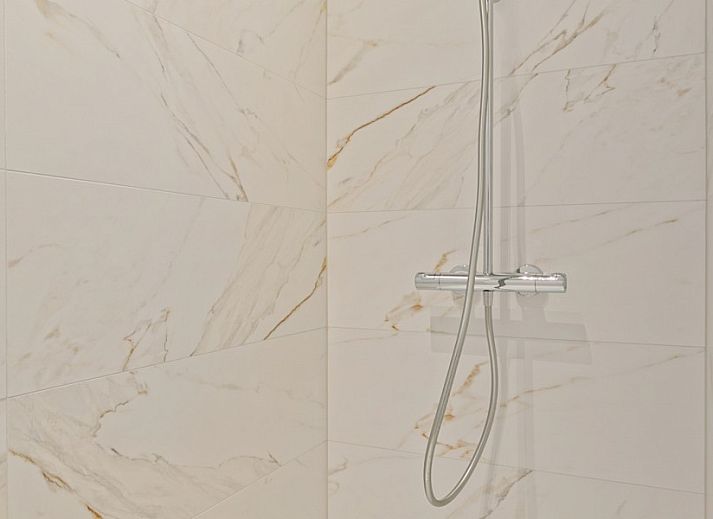 Gemuetliches Wohnzimmer von Maison Perron, Ferienhaus De Panne, Westflandern mit bequemem Sofa und Kunst an der Wand.