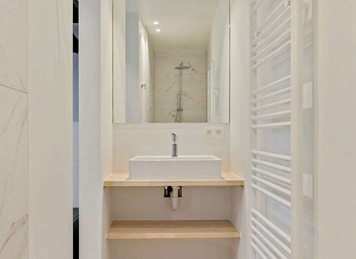 Gemuetliches Wohnzimmer von Maison Perron, Ferienhaus De Panne, Westflandern mit bequemem Sofa und Kunst an der Wand.