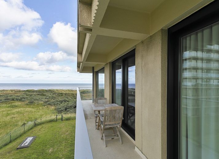 Balcony of Flat Fleur apartment in De Panne, West Flanders overlooking modern building and sea.