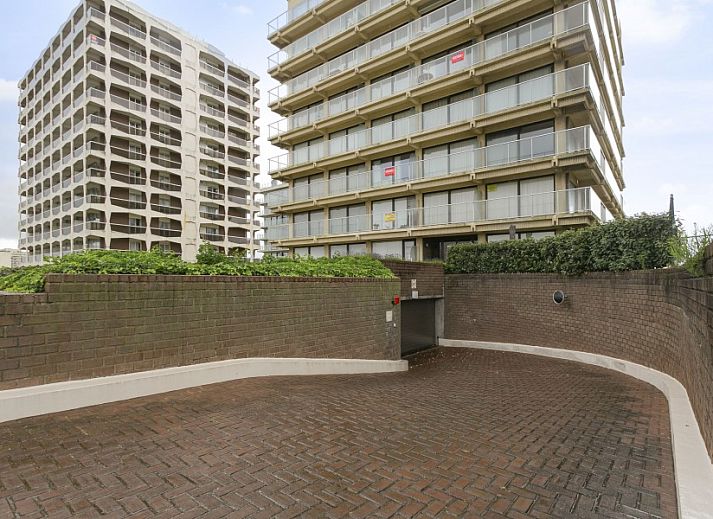 Balcony of Flat Fleur apartment in De Panne, West Flanders overlooking modern building and sea.